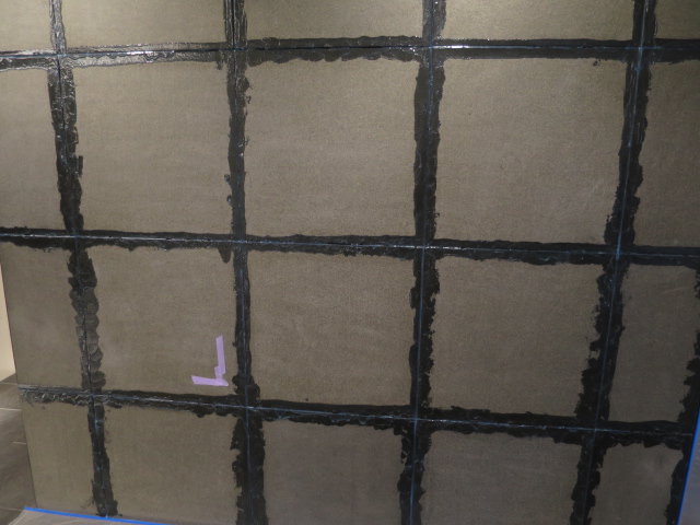 黒御影石バーナー仕上げの壁がシール材の影響で額縁状の濡れジミになって