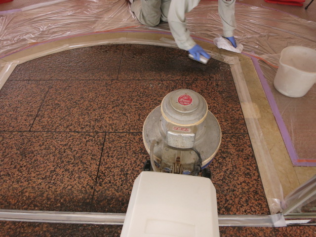 カーペットの張替え工事で、風除室の赤御影石バーナー仕上げ床が黒光りする汚れが付着して復元工事の依頼が